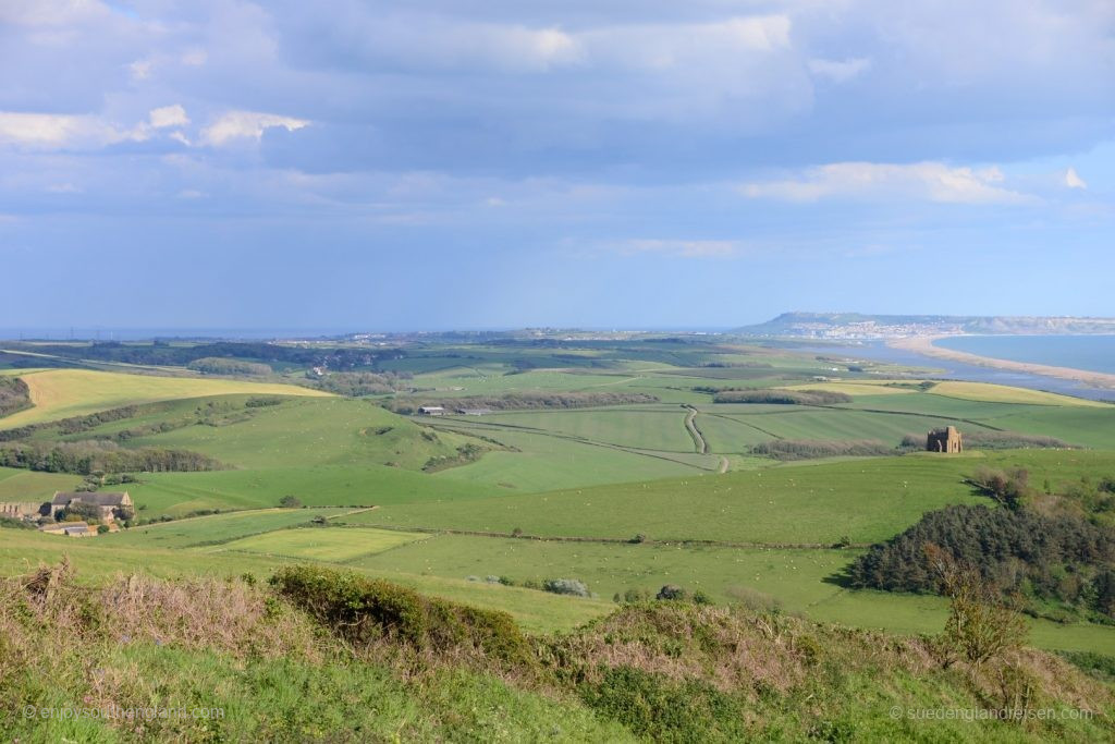 Ein Blick zurück: Links im Tal Abbotsbury, auf dem Hügel in der Mitte St. Catherines Chapel und rechts Chessil Beach an der Jurassic Coast