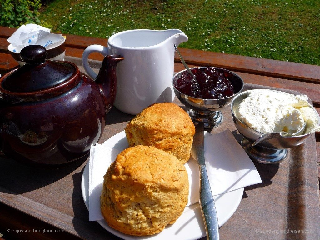 Ein klassischer Cream Tea: Zwei Scones (hier die normalen ohne Rosinen) und in den Schalen Unmengen von Clotted Cream und Jam (Marmelade). Dazu natürlich ein guter Tea mit frischer Milch.