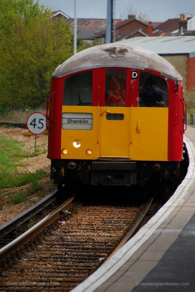 IOW Island Line - An Island Line train in the distinctive classic London Underground colors of red with yellow frontage entering Shanklin station.