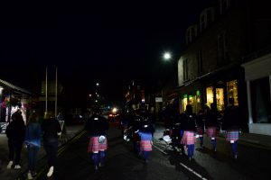 Die Zuschauer folgen des Pipes and Drums zurück auf die High Street von Pitlochry